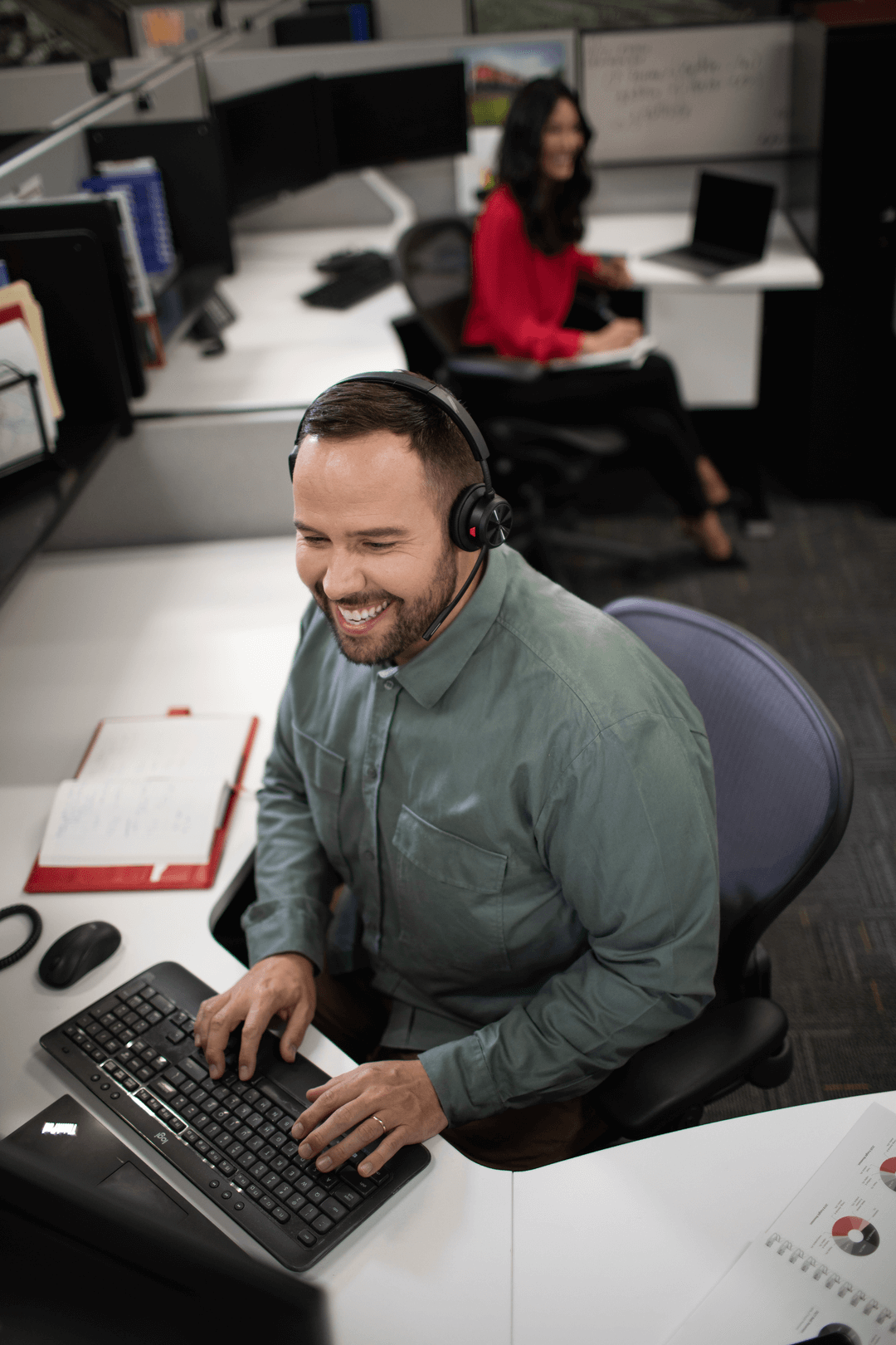 A person sitting in front of a computer with a headset on
